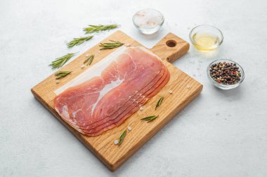 Jambon dilimleri tuz, otlar ve baharatlarla dilimlenmiş.