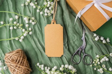 Çiçekli kraft etiketi ve hediye paketi aksesuarlarının üst görünümü