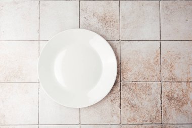 Kırsal fayans arkaplan görünümünde boş beyaz seramik plaka