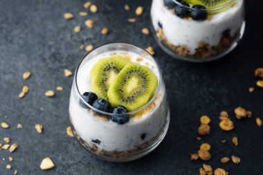 Koyu arkaplanda kivi ve yaban mersinli sağlıklı kahvaltı.