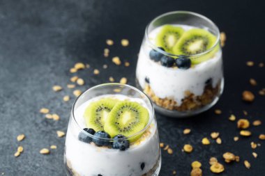 Koyu arkaplanda kivi ve yaban mersinli sağlıklı kahvaltı.