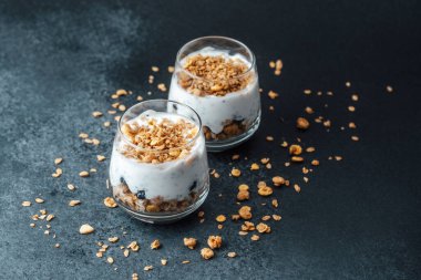 Koyu arkaplanda granola ve yoğurtlu parfümler.