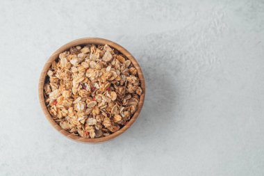 Yuvarlak ahşap kase ve arka planda granola yakın plan