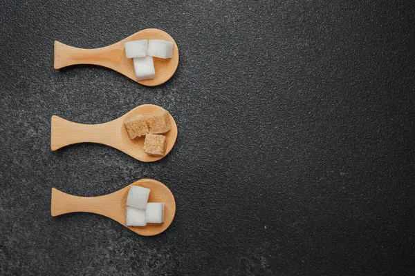 Tahta kaşıklarda sunulan farklı şeker türleri cezbedici bir şekilde düzenlenmiştir..