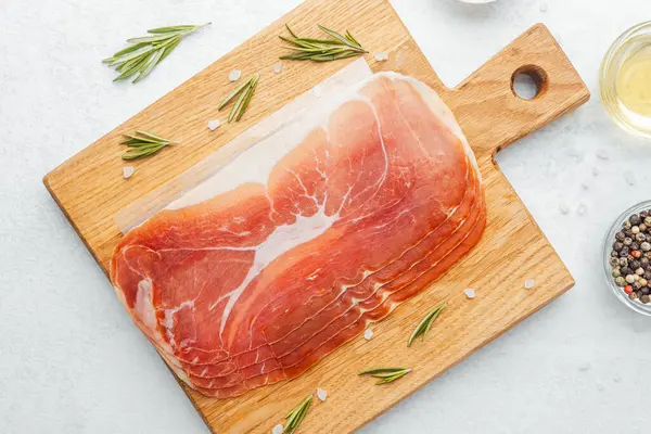 Jambon dilimleri tuz, otlar ve baharatlarla dilimlenmiş.