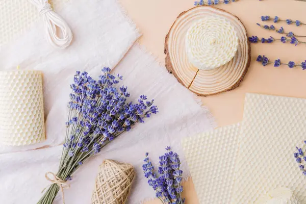 Balmumu mum ve lavanta buketi ağaç dilimi ve kumaş üzerinde