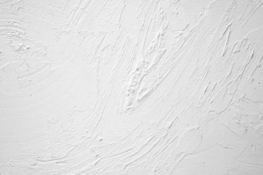 Sıva ayrıntılarını ve kalıplarını vurgulayan desenli beyaz bir duvarın yakın görünümü.