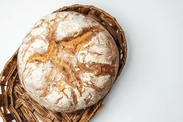 Taze pişmiş yuvarlak ekmek ve kabuklu bir dış sepet içinde duruyor..