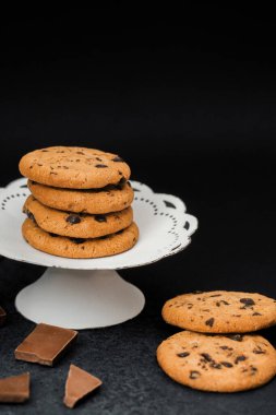 Çikolata parçalarıyla çevrili bir tezgahta taze pişmiş kurabiyeler..