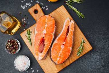 Somon filetoları tuz, biber ve otlarla pişirilmeye hazır..