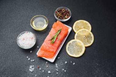 Somon filetosu yanında baharatlar, otlar, limon dilimleri ve tuzla hazırlanır..