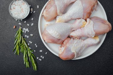 Tavuk budu çiğ, baharatlı ve otlu beyaz tabakta.