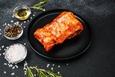 Biberiye ve tuzlu siyah tabakta baharatlı domuz kaburgası.