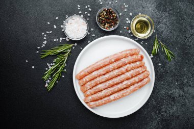Beyaz tabakta taze domuz sosisi ve baharat.