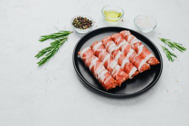 Domuz pastırması siyah tabakta baharat ve biberiye ile sarılmış.