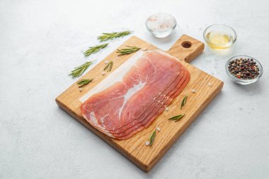 Jambon dilimleri tuz, otlar ve baharatlarla dilimlenmiş.