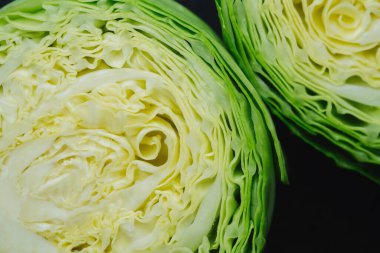 Karanlık arka planda iki kesik lahana parçası. Yakın plan.