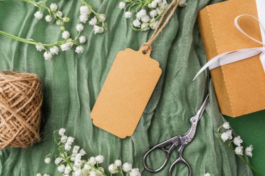 Çiçekli kraft etiketi ve hediye paketi aksesuarlarının üst görünümü