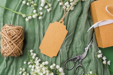 Çiçekli kraft etiketi ve hediye paketi aksesuarlarının üst görünümü