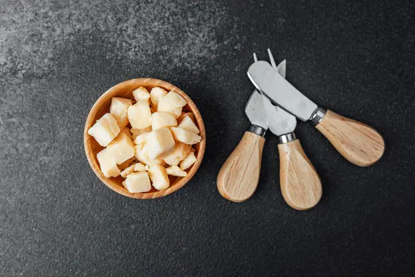 Bir kase peynir, siyah bir masanın üzerindeki aletlerin yanına konur..