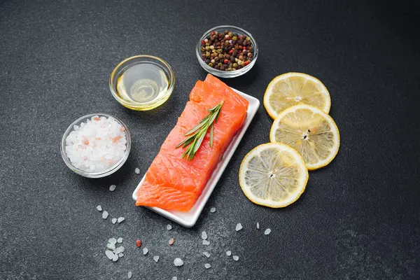 Somon filetosu yanında baharatlar, otlar, limon dilimleri ve tuzla hazırlanır..