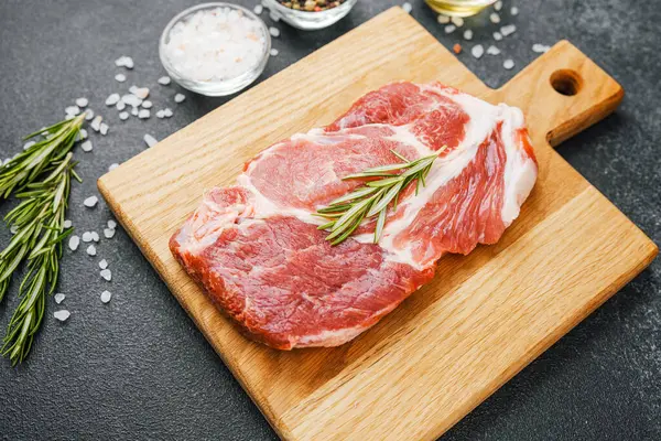 Biberiyeli çiğ biftek ve ahşap tahtada baharatlar.