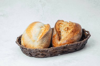 Kırsal bir sepetin içinde iki somun zanaatkar ekmek sunuluyor..