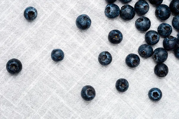 Olgun yaban mersinleri beyaz keten kumaşın üzerine yayılır. Atıştırmak ya da pişirmek için mükemmeldir..