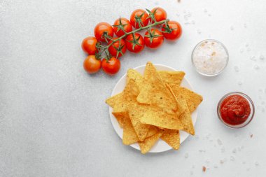 Domatesli çıtır cips, beyaz arka planda salsa ve tuz.