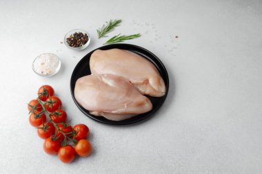 Çiğ tavuk göğsü ve taze domates, tuz, biber ve biberiye.