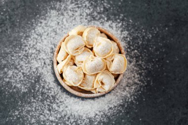 Ahşap kase un tozlu cappelletti makarna ile dolu.