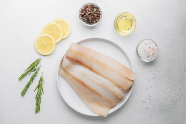 Beyaz arka planda limonlu ve biberiyeli ham pollock fileto.