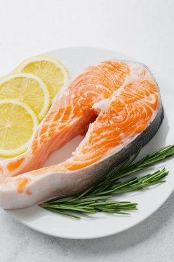 Limon dilimleri ve biberiyeli çiğ somon bifteği.