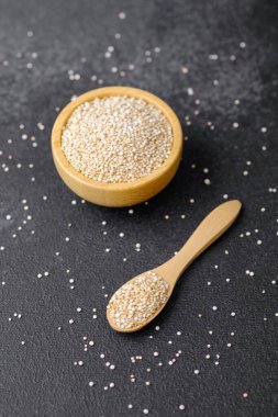 Tahta kasede kinoa tohumu ve dağınık tahıllı kaşık.