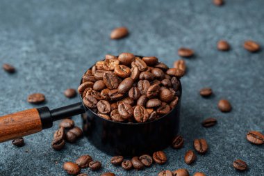 Kahve çekirdekleri koyu arkaplandaki kepçeyi ölçüyor