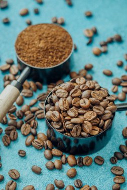 Kahve çekirdekleri ve mavi arka planda dağınık fasulyeler.