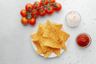 Domatesli çıtır cips, beyaz arka planda salsa ve tuz.