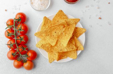 Domatesli çıtır cips, beyaz arka planda salsa ve tuz.