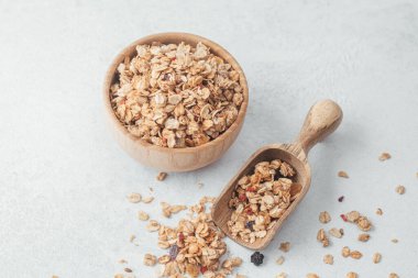 Tahta kasede granola ve açık gri arka planda kepçe