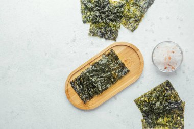 Beyaz arka planda bir kase tuzlu kavrulmuş yosun atıştırmalığı