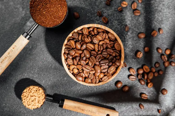 Kahve, hazır kahve, kepçe içinde fasulye ve arka planda ahşap kase.