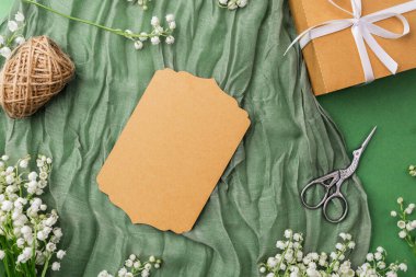 Yeşil arka planda çiçekler olan el işi kartı ve hediye kutusu