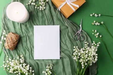 Mumlu boş kart, hediye ve yeşil kumaşta bahar çiçekleri.