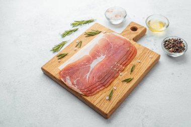 Jambon dilimleri tuz, otlar ve baharatlarla dilimlenmiş.