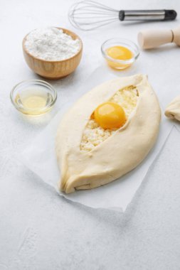 Yumurta sarısı ve beyaz arka planda çırpılmamış khachapuri.