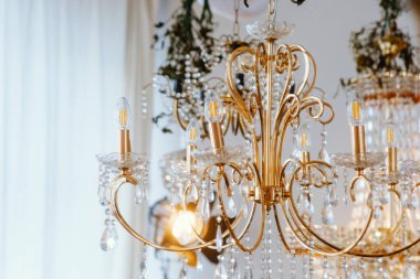 Güzel dizayn edilmiş kristalli bir avize iyi aydınlatılmış bir odada parlıyor..