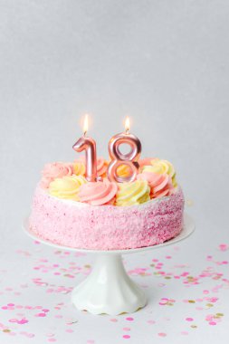18. yaş günü kutlaması için sarı ve pembe şekerli pembe bir pasta..