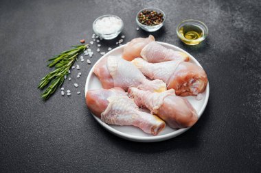 Tavuk budu çiğ, baharatlı ve otlu beyaz tabakta.