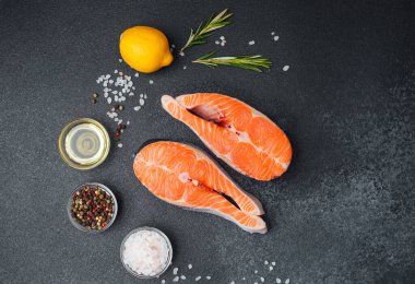 Somon fileto ve baharatlar, yakınlarda taze limon ve otlarla pişirilmek için hazırlandı..