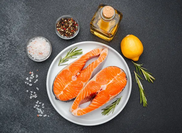 Somon filetosu baharat ve bitkilerin yanında pişirmeye hazır..